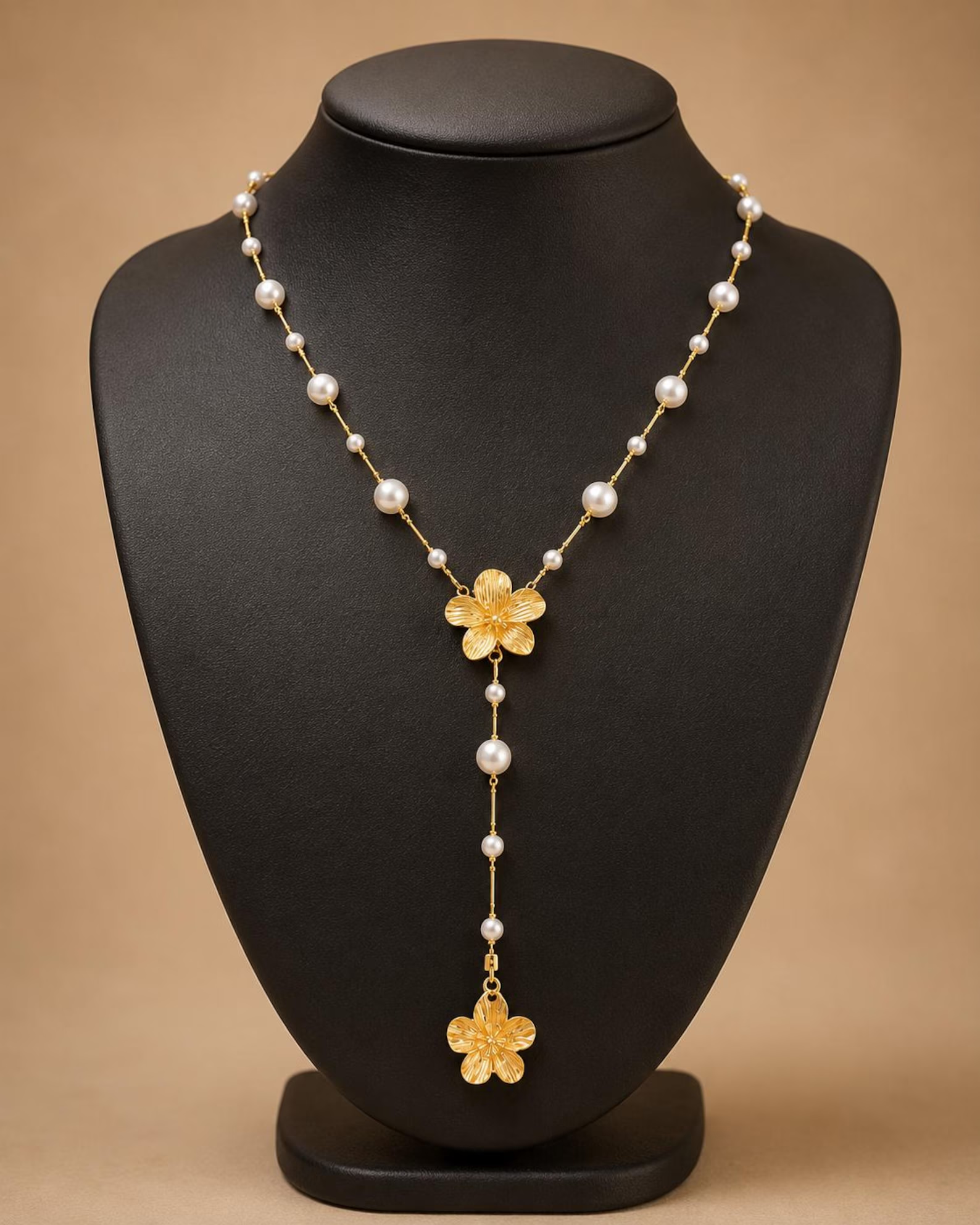 Hibiscus Flower Pearl Lariat Necklace displayed on a jewelry bust